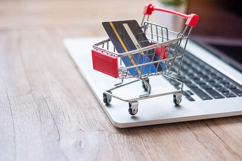 Shopping cart and credit card on laptop at home office. business